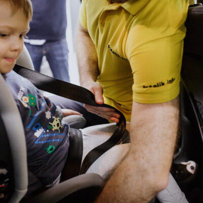 Kokia yra teisinga trijų taškų saugos diržo eiga vaikui, sėdinčiam automobilinėje kėdutėje?